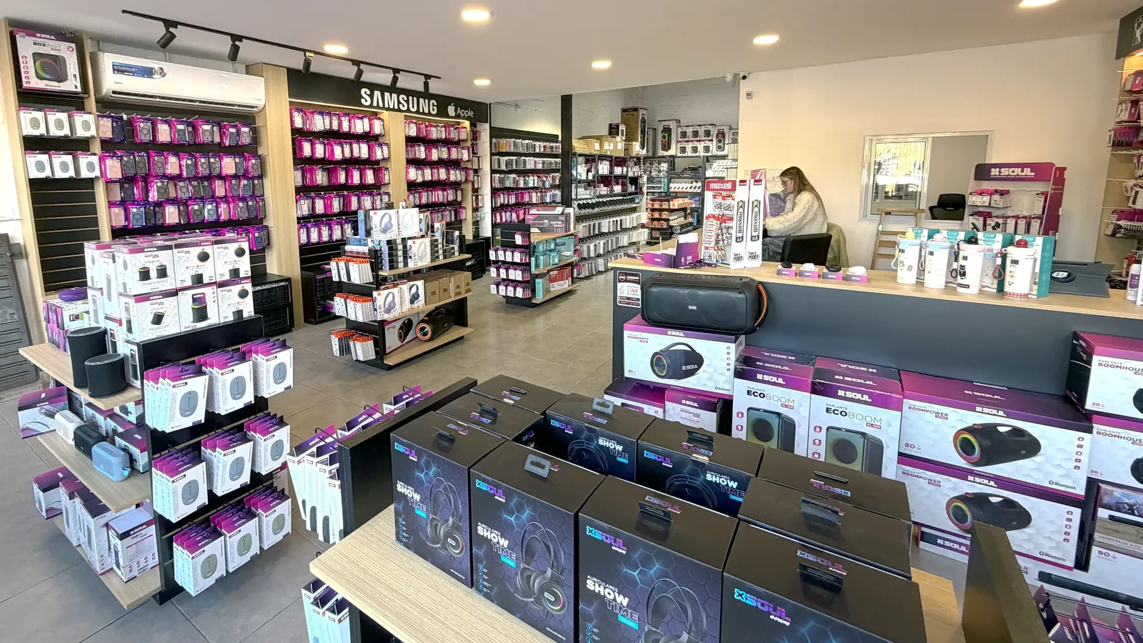 G&oacute;ndolas del sal&oacute;n mayorista cargadas de parlantes, auriculares y fundas